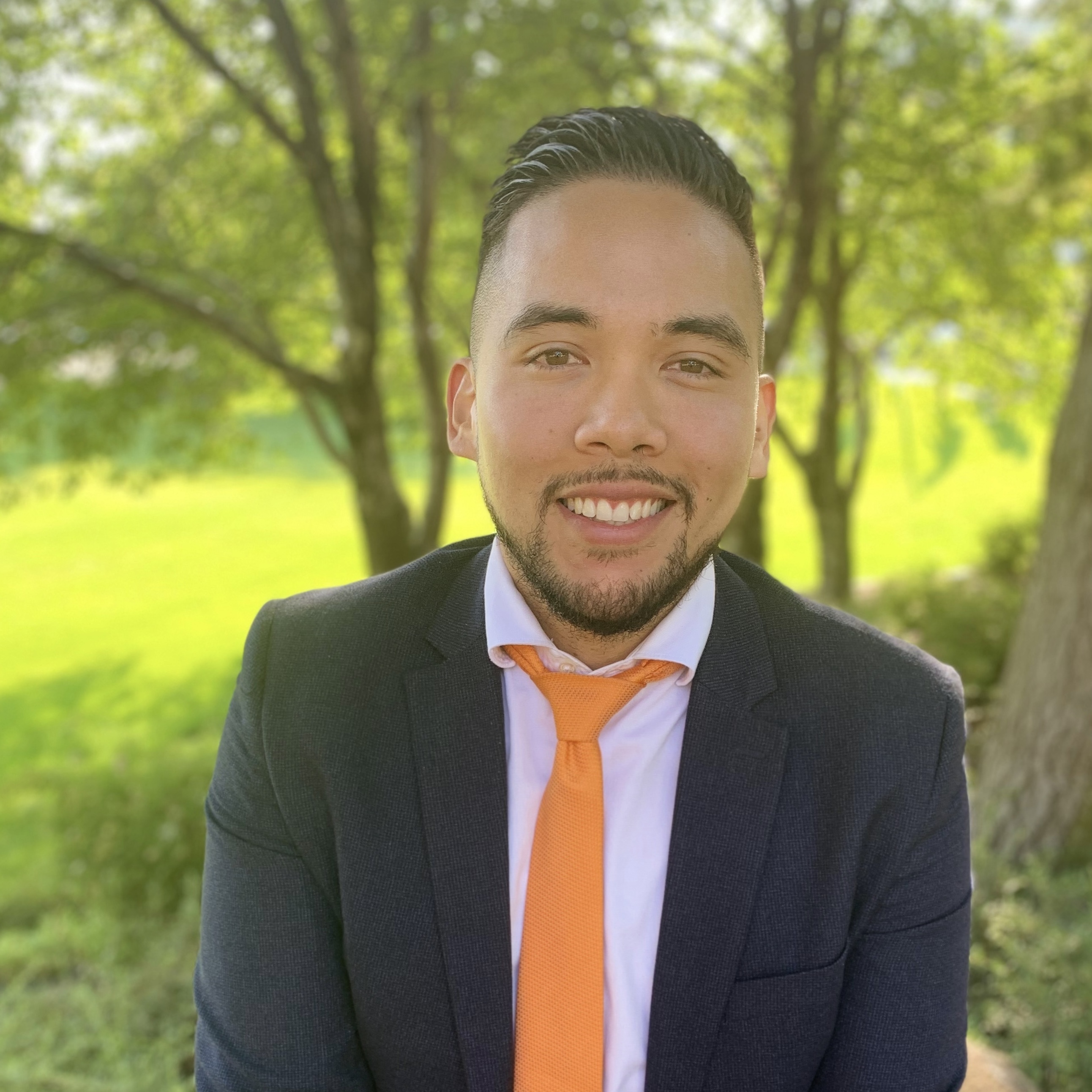 Young man with dark hair with white shirt, yellow tie and blue jacket